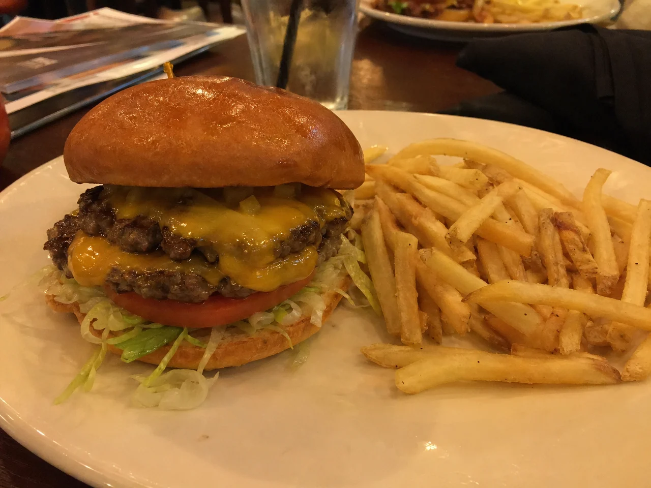 Amateur phone photo of a burger in dim restaurant lighting